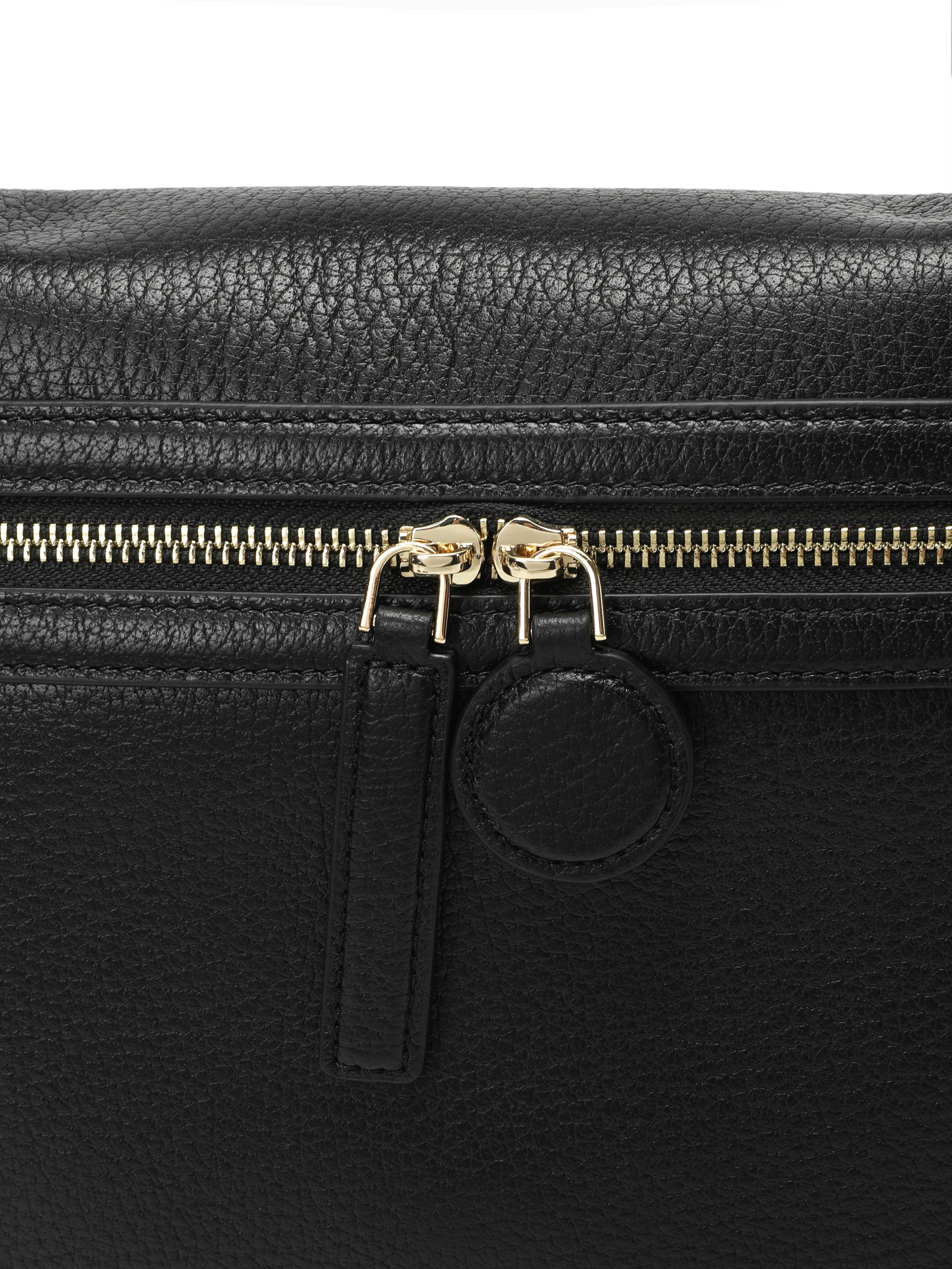 Close-up of black leather handbag with gold zipper and textured finish