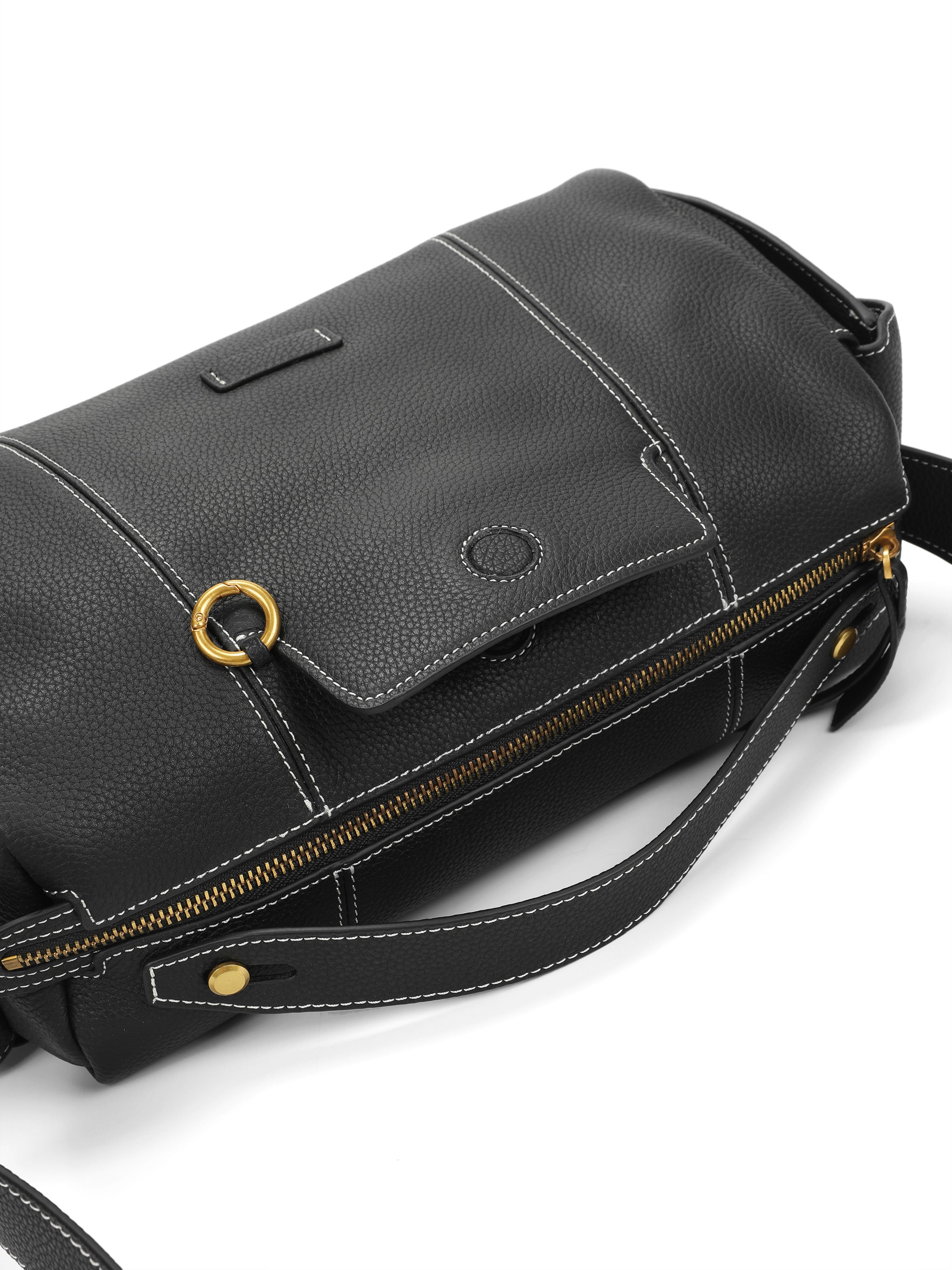 Black leather handbag with gold hardware, white stitching, and zip closure on white background.