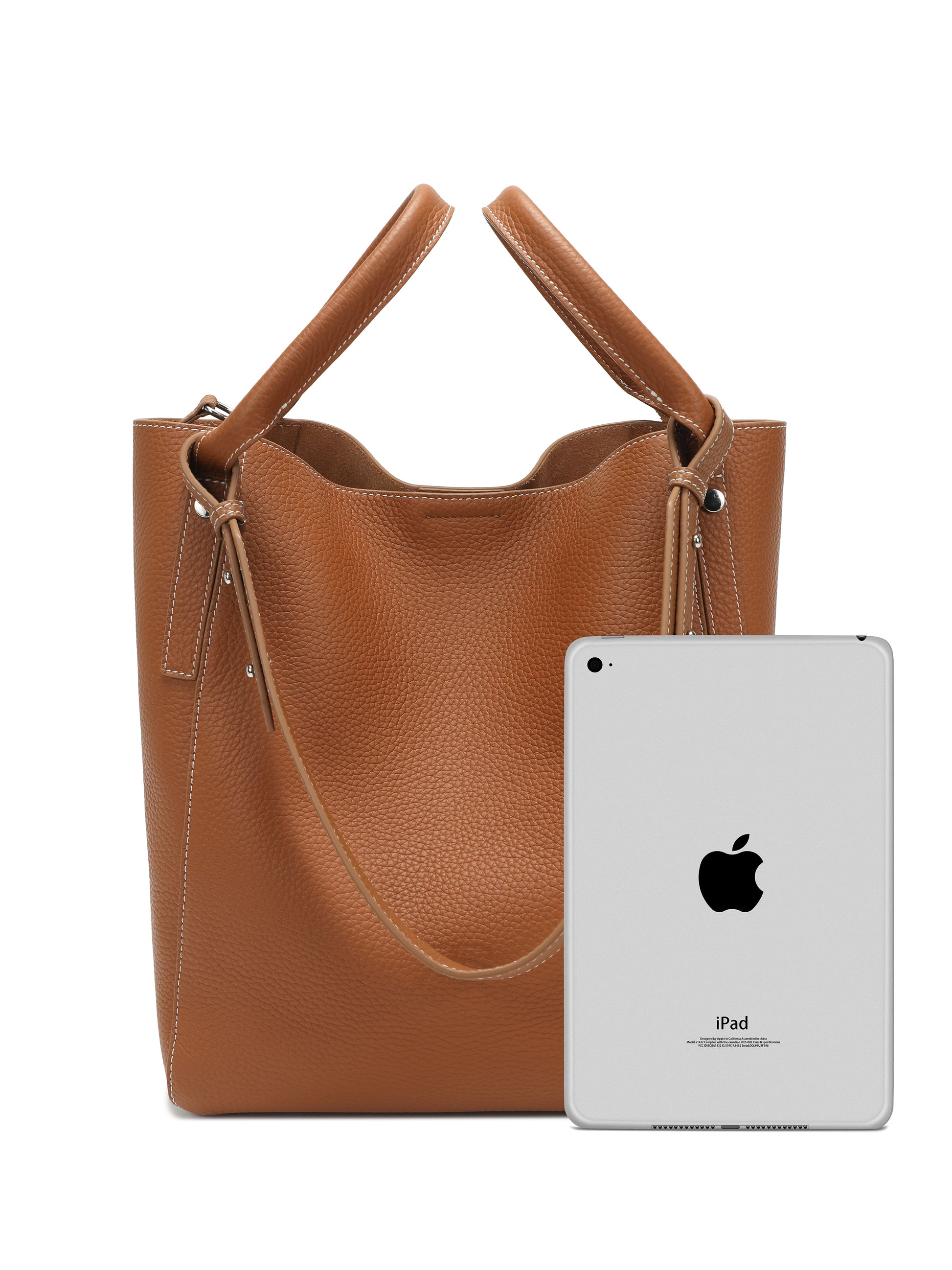 Brown leather tote handbag with top handles and shoulder strap, shown with tablet for size reference