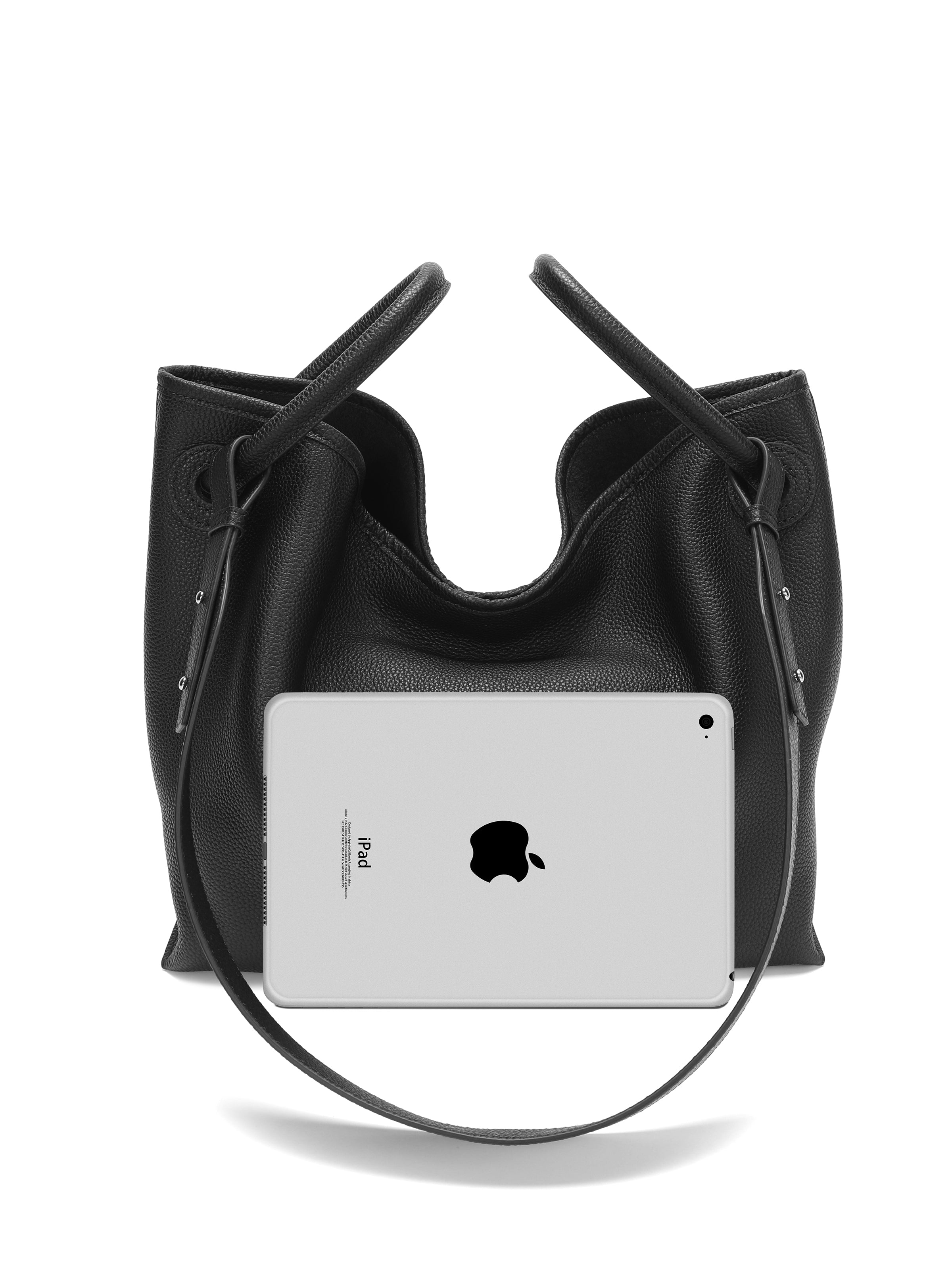 Black leather tote handbag with shoulder strap shown with iPad for size reference