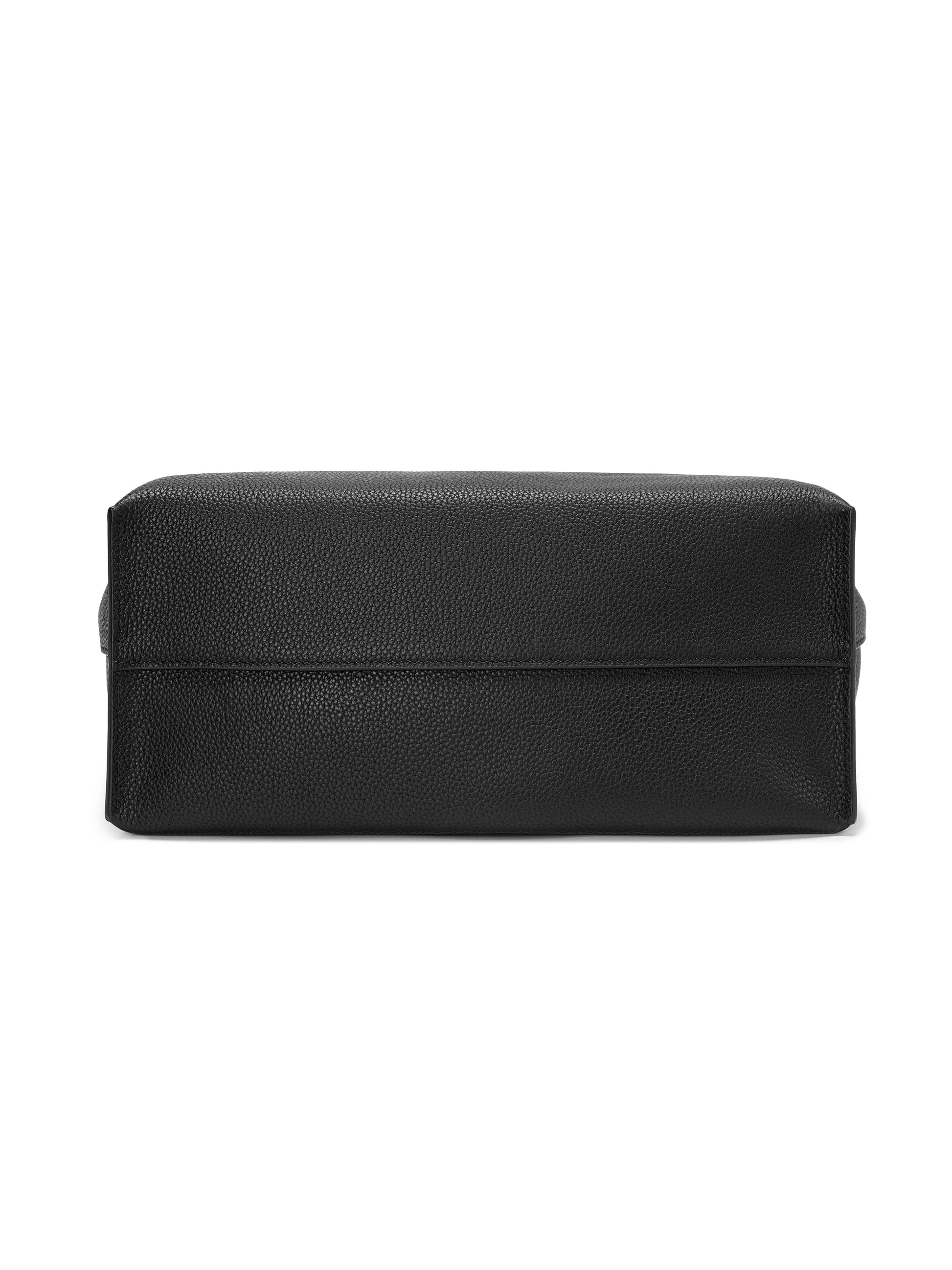 Bottom view of black leather handbag with textured finish on white background