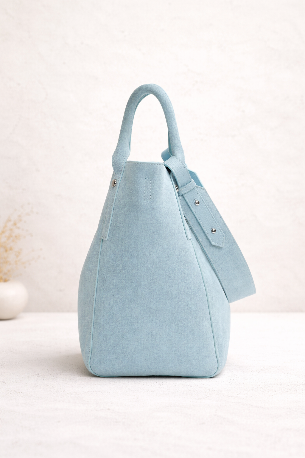 Light blue suede hobo bag with top handle and minimalist design